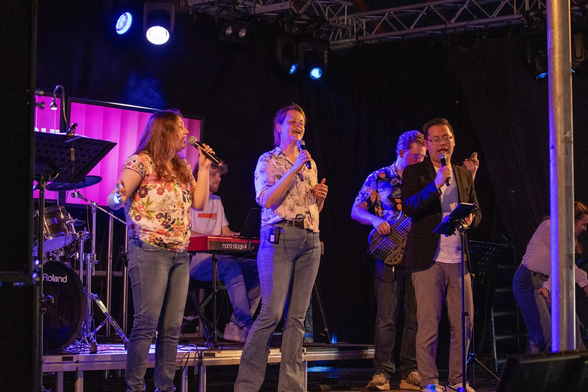Zangers van de band samen op het podium